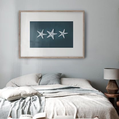 This Beach Poster Print  art work featuring a starfish trilogy on a dark background. This beach house style is perfect for creating a coastal retreat.